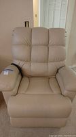 Front view of a tan massage recliner chair showing cushioned high back, padded armrests, and seat.