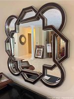 Front view of the 40 x 40 inch mirror hung on the wall showing the geometric segmented frame and reflective glass.