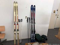 Photo showing full view of both pairs of skis, both pairs of poles, and travel bag.