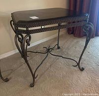 Full view of square table with grinding top and decorative metal base on carpet