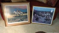 Two framed Native American themed limited edition prints titled 'Indian Justice' and 'Twilight Attack' placed side by side on a couch.