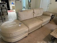Beige leather LazyBoy sofa with three seat cushions and three back cushions. Sofa appears large and in a living room setting.