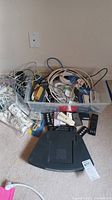 Bin of assorted cables, wires and remotes