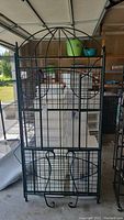Front view of the green metal folding wire shelving unit with dome top and grid shelves.