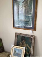 Full view of three framed paintings leaning against a wall, showing sizes and framing details.
