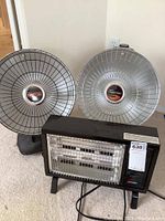 Two Presto HeatDish heaters and one Climate Keeper Radiant heater shown together indoors on floor.