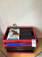 Photo showing stacked storage totes with red, blue, and black rims. Tag labeled Insta Crate visible.