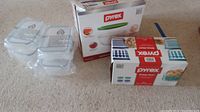Photo shows Pyrex glass storage containers without lids in plastic wrapping next to boxes.