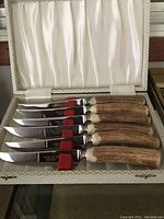 Set of six stag-handled carving knives in original box with satin interior, blades etched with 'COX CUTLERY'