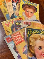 Overall view of eight visible magazines fanned on a wooden surface