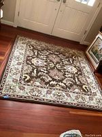 Full view of Safavieh Heritage area rug placed on wooden floor, showing design and size.