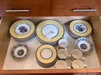 Overview of drawer with stacked dinner plates, side plates, bowls, saucers, and cups