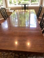 Top view of the wooden dining table showing polished wood surface and natural wood grain with light scratches.