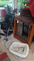 Pet gate, pet stroller, two pet beds, and some accessories grouped together