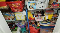Wide view of two chrome metal shelving units filled with assorted items including toys, books, and storage baskets.