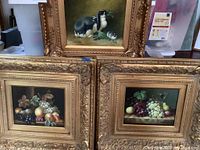 Three original paintings in ornate gilt frames, showing two fruit still lifes and one rabbits painting.