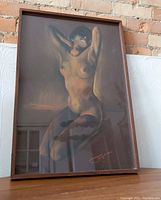 Framed female nude artwork with visible details of the figure and frame.