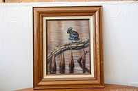 Frontal view of the framed painting showing the wood duck on a branch and details of wood frame and matting.
