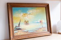 Frontal image of the wood framed nautical painting resting on a wooden surface, showing the full artwork and frame.
