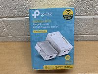 Front view of the boxed TP-Link 300Mbps Wi-Fi Range Extender AV600 Powerline Edition kit showing product image and key features.