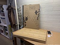 Cutting board and packaging box in storage room showing the Prosumer's Choice brand name and hexagon pattern on the box.