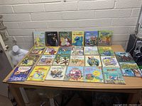 Top-down view of 26 Little Golden Books arranged on a table showing titles and cover art.