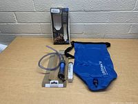 Set includes LifeStraw multi-use water filter, gravity bag in blue, and additional filter cartridge seen on table with original packaging box in background.