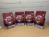 Photo showing four bags of Purina One Smartblend Healthy Puppy dog food lined up against a brick wall, displaying front packaging details.