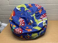 Front view of the bean bag showing colorful marine animal print on blue fabric.