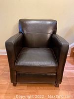 Front view of chair showing overall shape, leather upholstery, cushion and legs