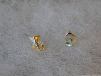 Close-up photo of sterling silver pyramid stud earrings placed on a fuzzy textured background.