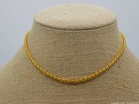 Gold tone rounded box link chain necklace displayed on a beige mannequin bust showing the chain shape and length.