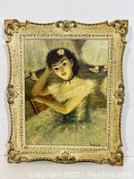 Full view of framed reproduction painting of seated ballerina with ornate vintage frame showing some wear.