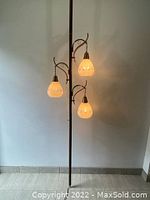 Full view of tension pole lamp with three hanging lights