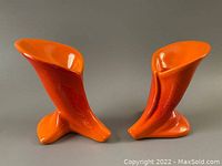 Front view of both Royal Haeger ceramic candle holders, showing atomic orange color and unique lily and leaf shapes.