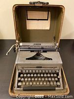 Open vintage Royal Quiet Deluxe typewriter inside its hard shell carrying case showing keyboard and platen roller.