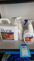 Photo showing three Bona Hardwood Floor Cleaner bottles: one large 250 oz refill container and two smaller spray bottles (29 oz and 24 oz).