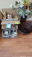 Photo showing the entire lot including candles, candle holders, plastic flowers, and basket on wood floor