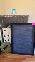 Framed chalkboard, USA map canvas, small mirror, abstract art, green wreath arranged together.