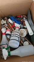 Top view of box showing assorted copper piping, fittings, spray bottles and tools