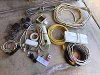Full overview of the lot showing collection of cords, wires, power strips, AC adapters, various cables and small electrical components.