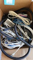 Box containing assorted telephone and Ethernet cables, plastic spiral wire coils, and a punch-down block.