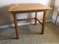 Front and top view of the solid wood drawing desk with a rectangular tabletop and four legs connected by cross supports.
