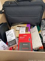 Top-down view of box showing laptop bag and various boxed and loose items