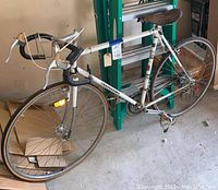 Side view of the white Peugeot men's road bike showing frame, front and rear wheel, drop handlebars, and saddle.