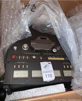 Top-down view of tape deck in protective plastic and foam in shipping box