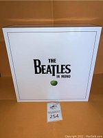 Front of white slipcase featuring “The Beatles In Mono” text and green apple logo.