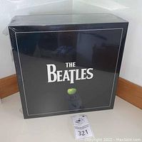 Front of sealed black box set with The Beatles logo and green apple