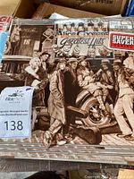 Alice Cooper Greatest Hits album cover showing sepia group photo with a cannon, Super Saver Series sticker, auction tag and plastic protective cover.