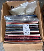 Full box of LaserDisc videodiscs showing stacked cardboard sleeves and loose plastic sleeves on top